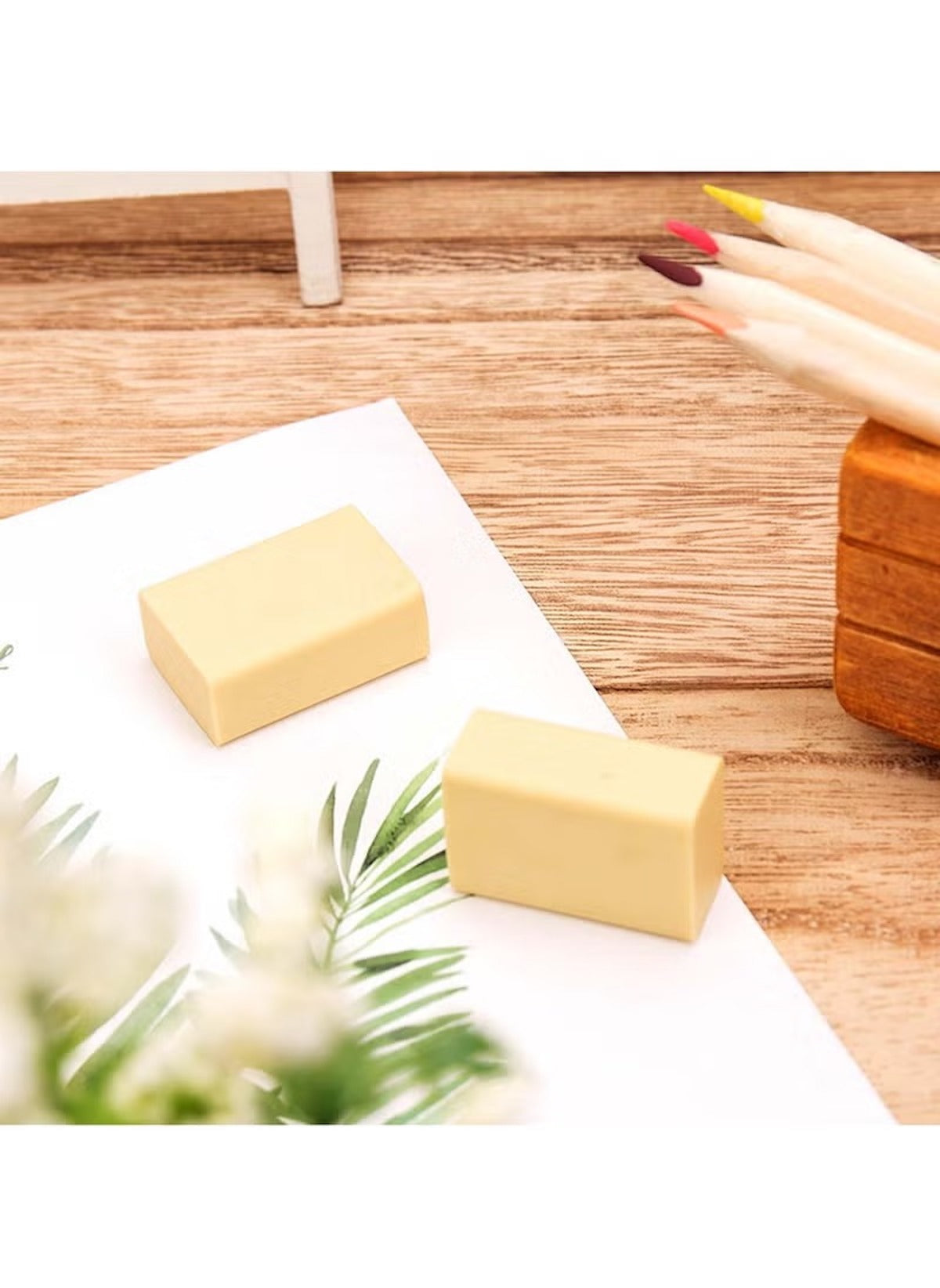 Huitich 4B art erasers bulk pack showing two light beige erasers on a wooden desk with pencils and a plant Huitich 4B art erasers bulk pack showing two light beige erasers on a wooden desk with pencils and a plant
