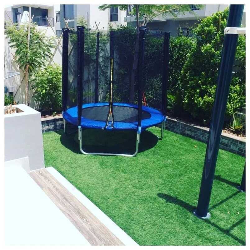 Huitich 6ft kids trampoline with safety net set up on green lawn in backyard Huitich 6ft kids trampoline with safety net set up on green lawn in backyard