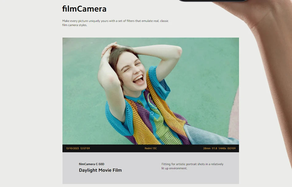 Xiaomi Redmi 13C global version sample photo on webpage showing laughing woman in colorful knit vest Xiaomi Redmi 13C global version sample photo on webpage showing laughing woman in colorful knit vest