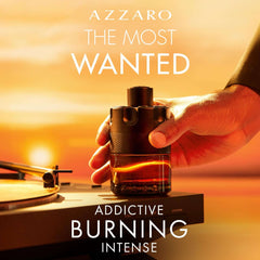 Azzaro The Most Wanted Parfum for men bottle held by hand with warm sunset background Azzaro The Most Wanted Parfum for men bottle held by hand with warm sunset background