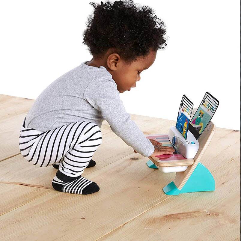 Baby playing with Huitich Baby Einstein Magic Touch Piano wooden toy on floor Baby playing with Huitich Baby Einstein Magic Touch Piano wooden toy on floor