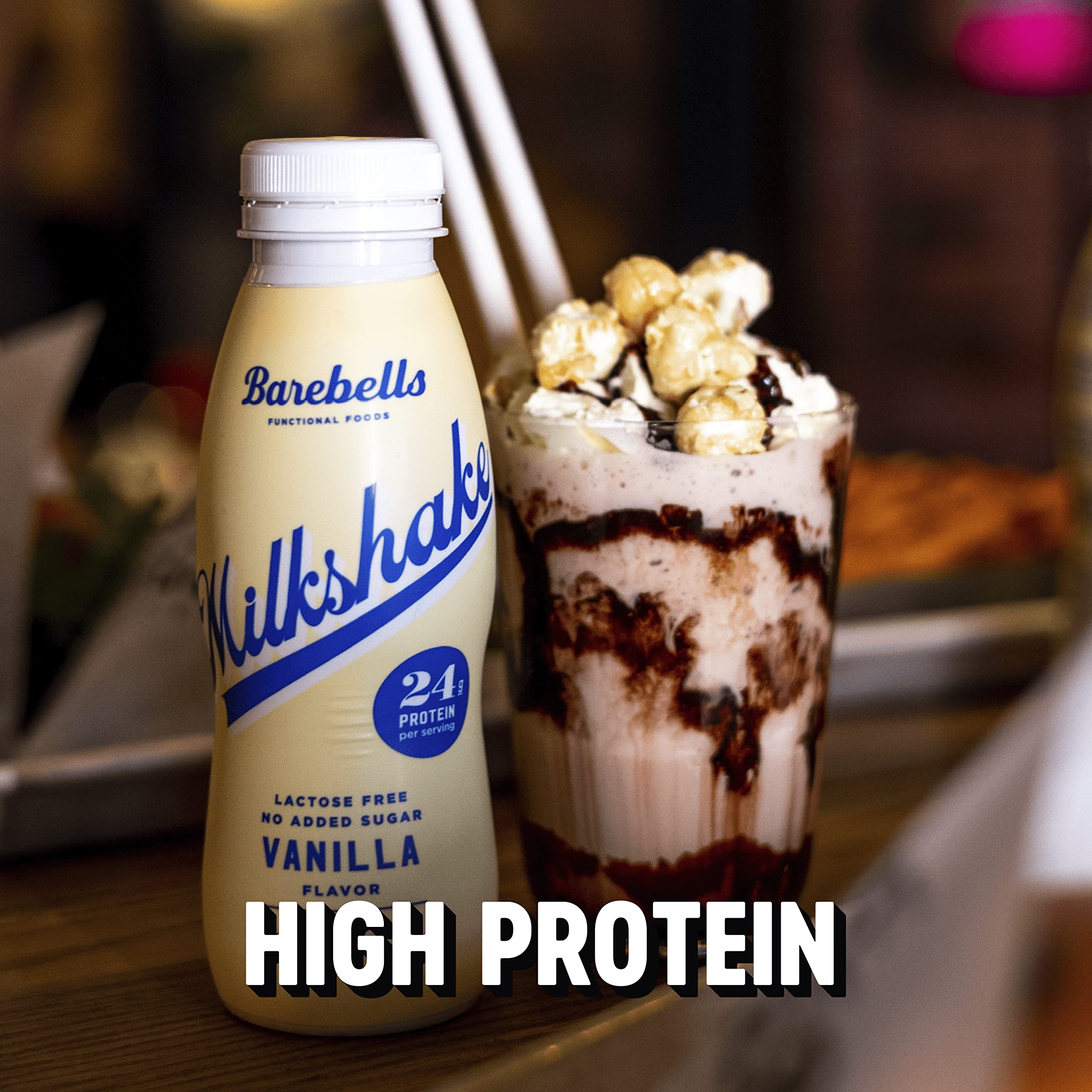 Barebells protein milkshake vanilla bottle beside a chocolate drizzled dessert glass topped with popcorn in a cafe Barebells protein milkshake vanilla bottle beside a chocolate drizzled dessert glass topped with popcorn in a cafe