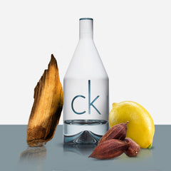 CK IN2U Eau De Toilette 100ml bottle with lemon, wood, and seed accents representing fragrance notes CK IN2U Eau De Toilette 100ml bottle with lemon, wood, and seed accents representing fragrance notes