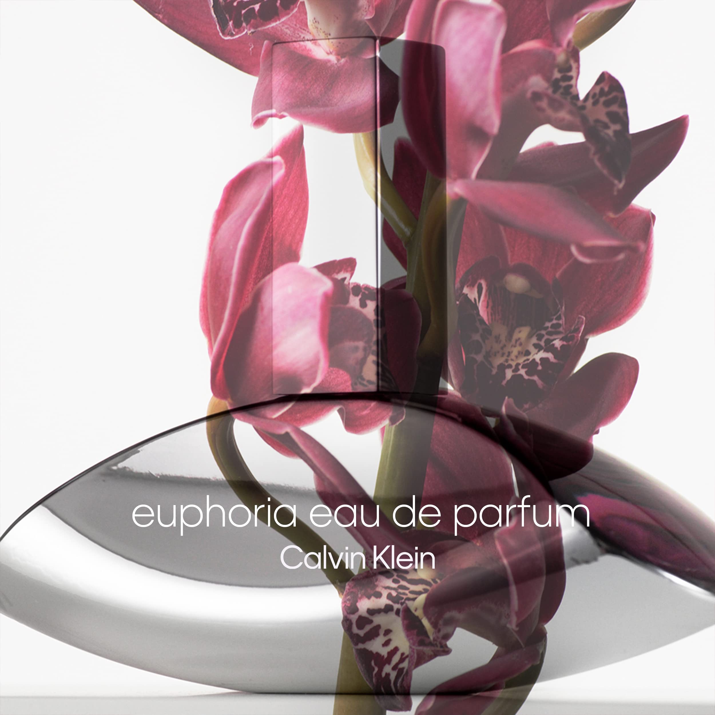 Calvin Klein Euphoria perfume for women bottle with pink orchid flowers in the background Calvin Klein Euphoria perfume for women bottle with pink orchid flowers in the background