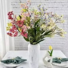 Huitich decorative fake roses for weddings in a white vase on a dining table with green napkins Huitich decorative fake roses for weddings in a white vase on a dining table with green napkins
