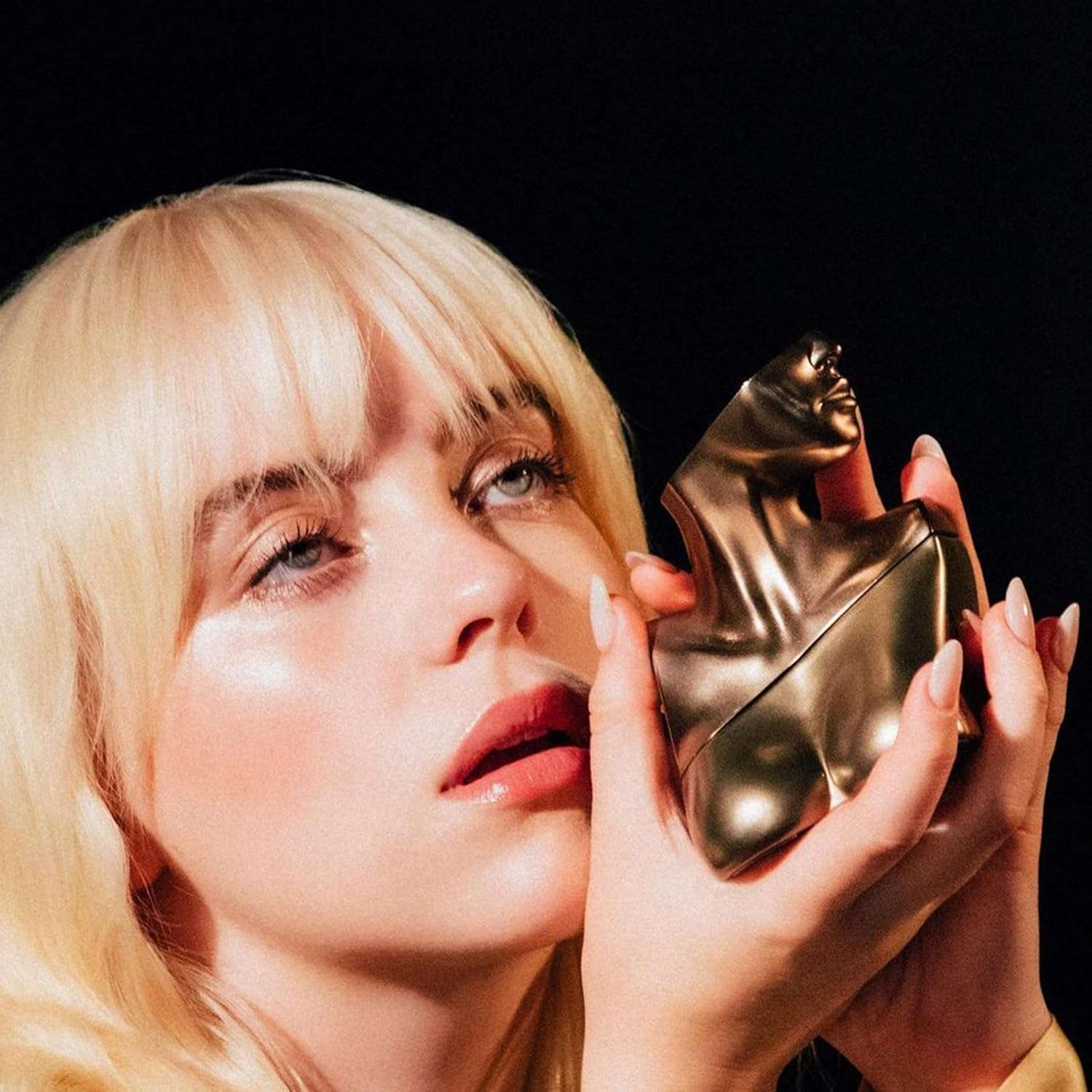 Woman holding unique sculpted bottle of Eilish Eau de Parfum for women from Billie Eilish Store Woman holding unique sculpted bottle of Eilish Eau de Parfum for women from Billie Eilish Store