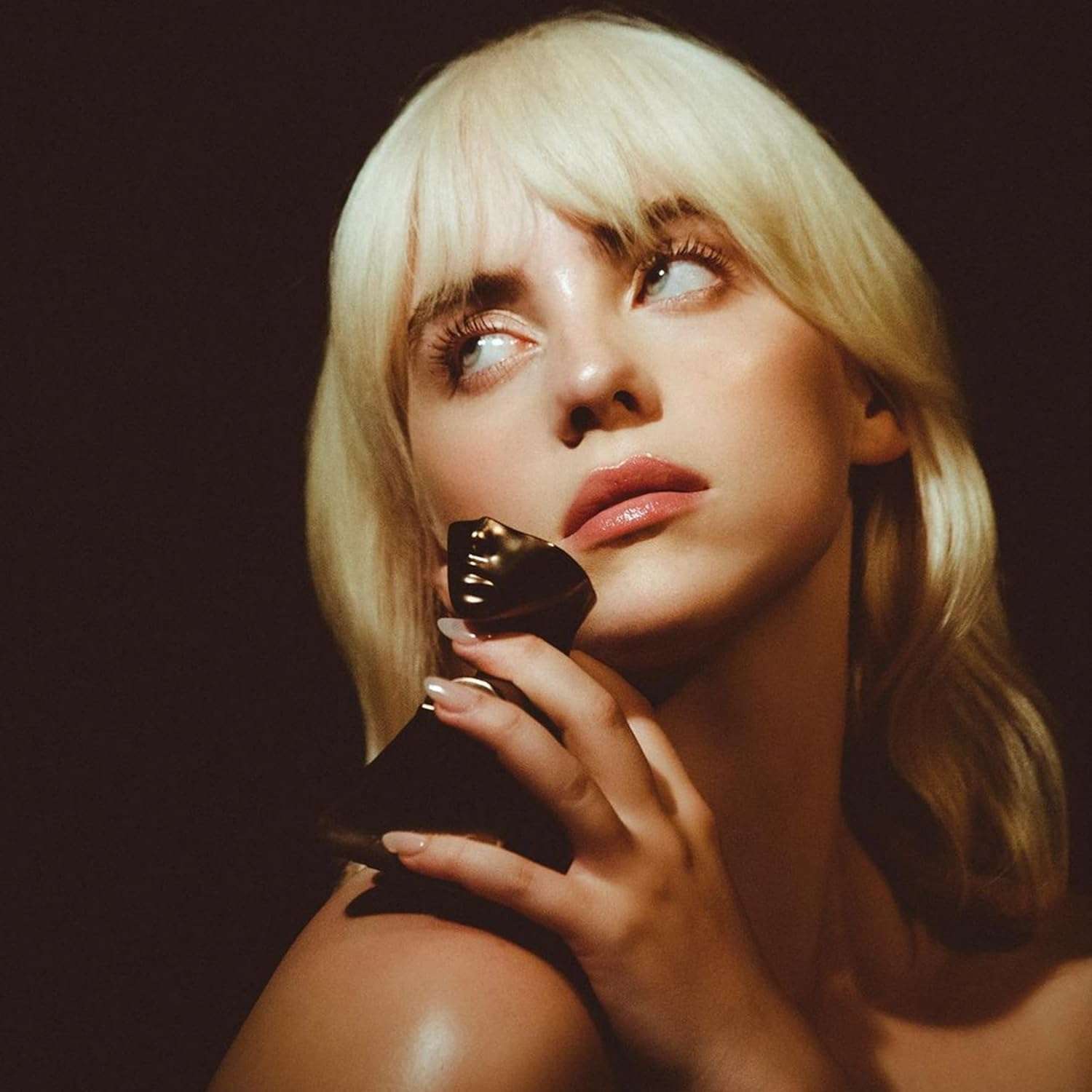 Woman holding Eilish Eau de Parfum for women bottle from Billie Eilish Store with thoughtful expression Woman holding Eilish Eau de Parfum for women bottle from Billie Eilish Store with thoughtful expression