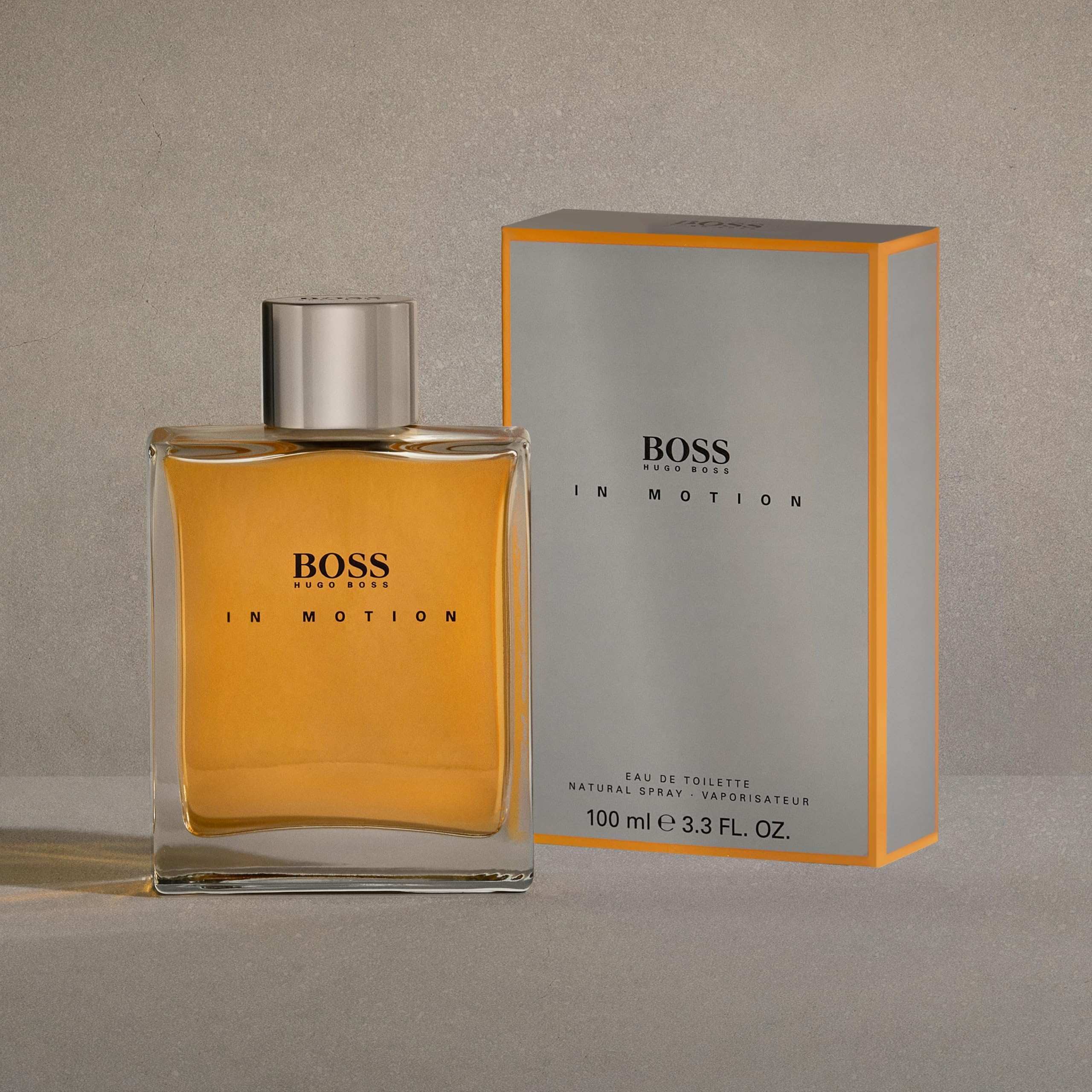 Hugo Boss In Motion for men eau de toilette bottle and packaging with amber liquid and silver cap Hugo Boss In Motion for men eau de toilette bottle and packaging with amber liquid and silver cap