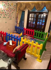 Colorful Huitich childrens play area fence set up indoors with red, blue, yellow, and green panels surrounding toys Colorful Huitich childrens play area fence set up indoors with red, blue, yellow, and green panels surrounding toys