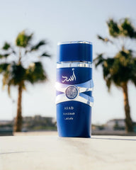 Lattafa Asad Zanzibar perfume men blue bottle with silver accents and palm trees background Lattafa Asad Zanzibar perfume men blue bottle with silver accents and palm trees background