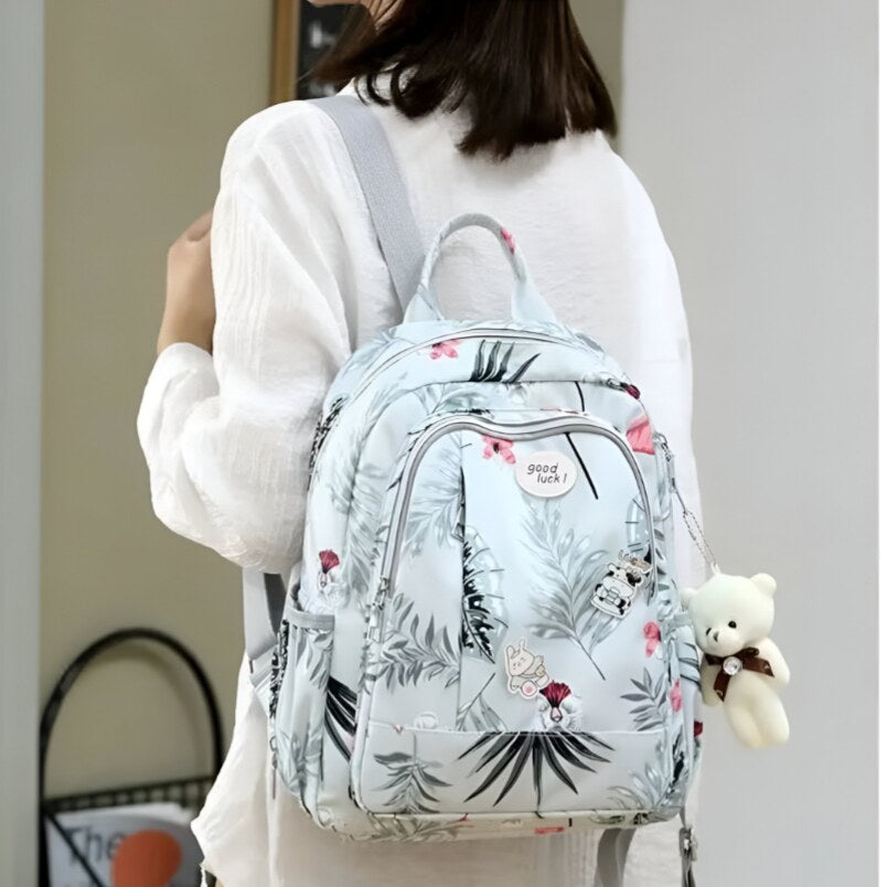 Huitich moms diaper backpack with floral print in light blue worn by woman with white shirt Huitich moms diaper backpack with floral print in light blue worn by woman with white shirt