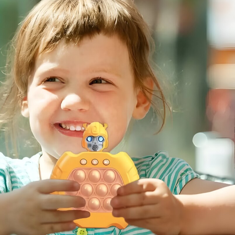 Child holding yellow robot pop fidget toy with bubble pop design by Huitich smiling outdoors Child holding yellow robot pop fidget toy with bubble pop design by Huitich smiling outdoors
