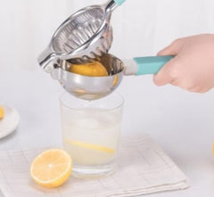 Huitich stainless steel lemon squeezer with blue handle pressing lemon over glass of lemonade Huitich stainless steel lemon squeezer with blue handle pressing lemon over glass of lemonade