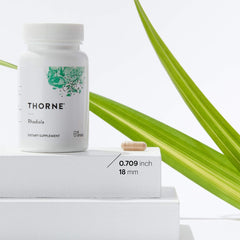 THORNE Rhodiola supplement for stress relief bottle with capsule on white pedestal and green leaf THORNE Rhodiola supplement for stress relief bottle with capsule on white pedestal and green leaf