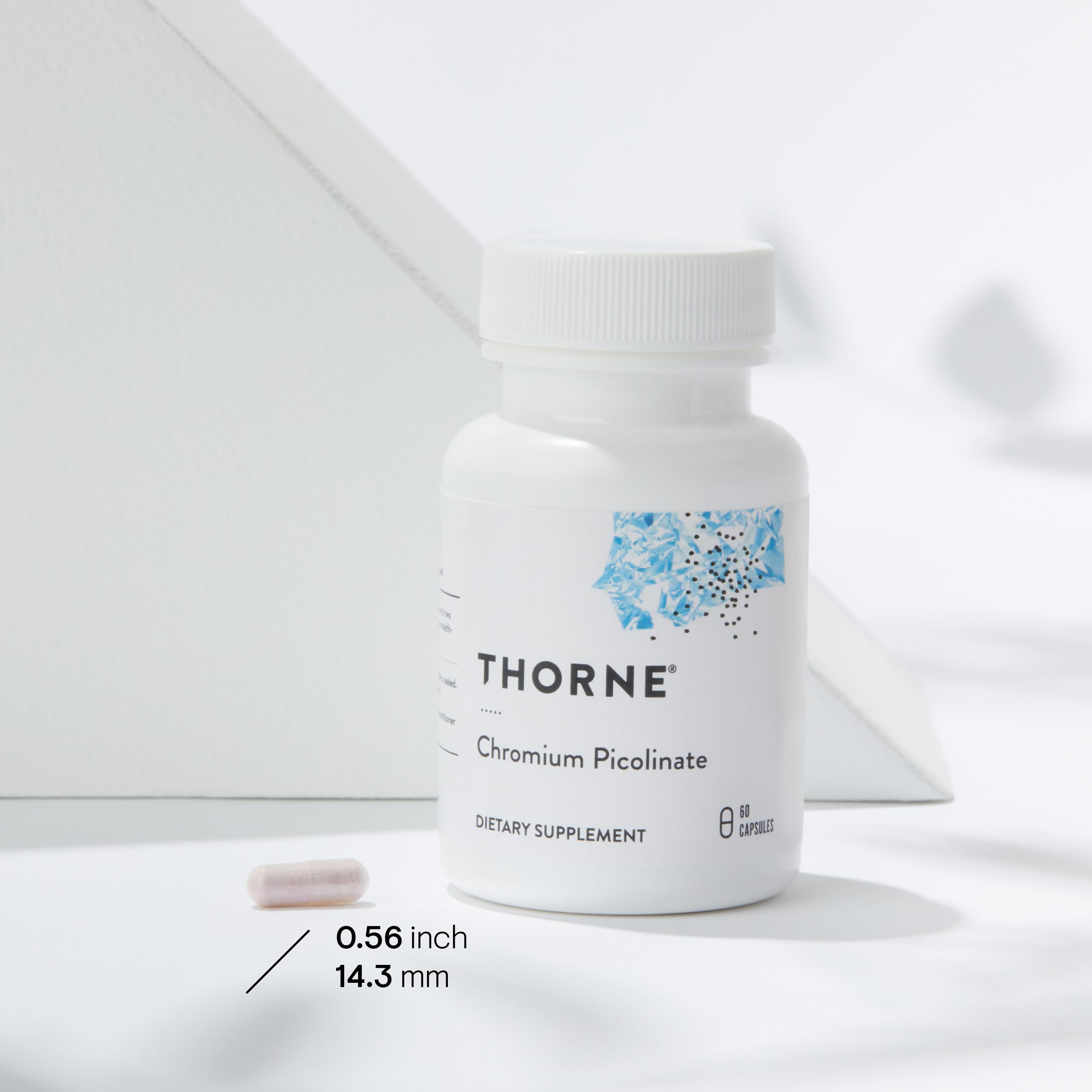 Thorne chromium for blood sugar support supplement bottle and single capsule on white background Thorne chromium for blood sugar support supplement bottle and single capsule on white background