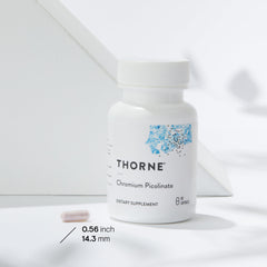 Thorne chromium for blood sugar support supplement bottle and single capsule on white background Thorne chromium for blood sugar support supplement bottle and single capsule on white background