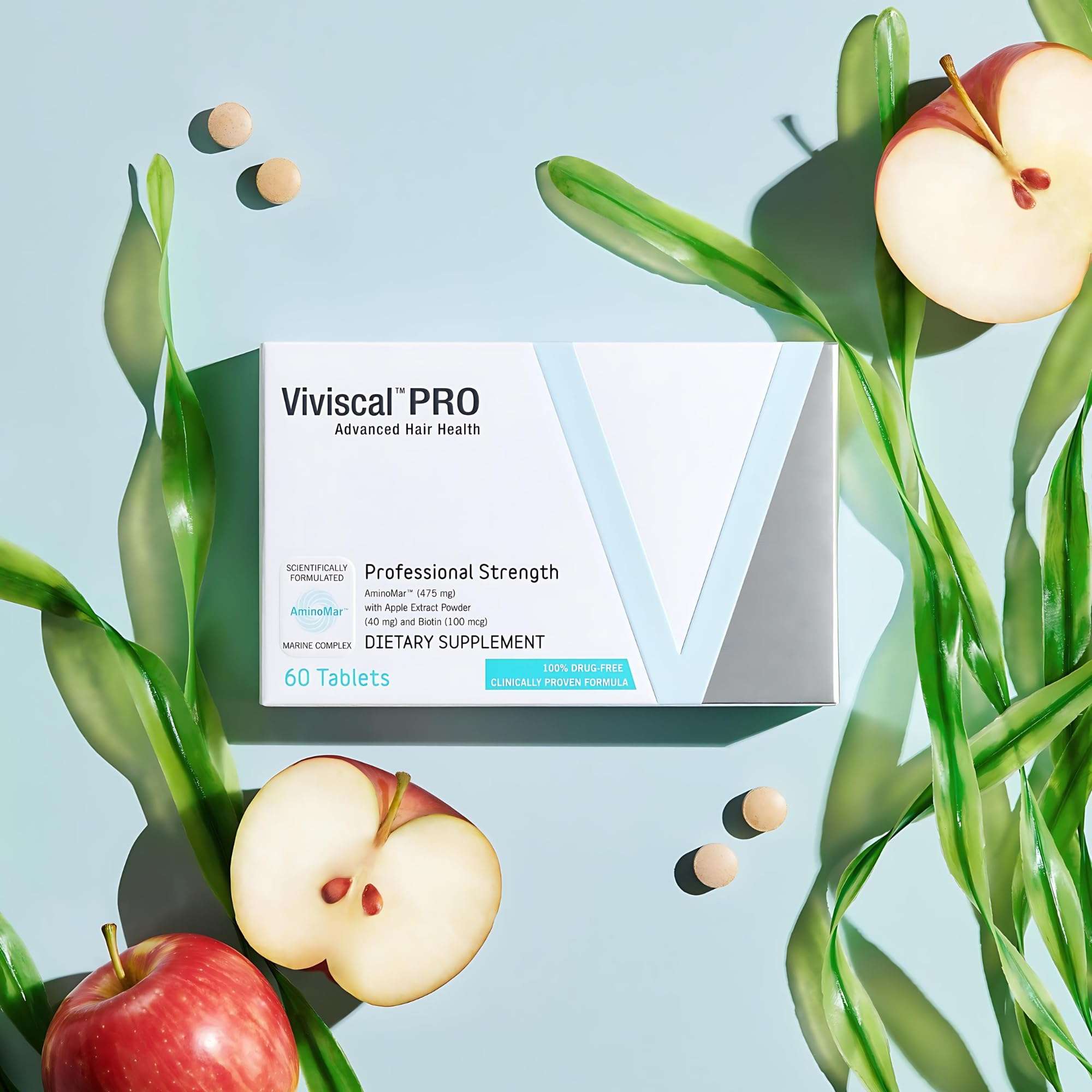 Box of Viviscal PRO hair growth supplements with tablets displayed beside apples and seaweed Box of Viviscal PRO hair growth supplements with tablets displayed beside apples and seaweed