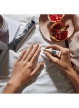 Hands applying nail and cuticle oil using a small tube and bottle