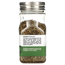 Jar of dried basil leaves with green ingredient label on back, clear glass bottle