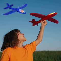 Child playing outdoors with 2 pack light up airplane kids sport toys in red and blue colors