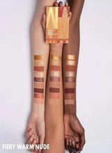 Eyeshadow palette in warm nude tones held above arm with multiple shade swatches