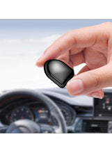 Small black adhesive car hook held by hand, rounded shape