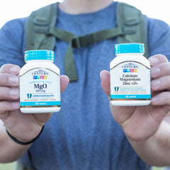 Person outdoors holding 21st Century supplements showing calcium magnesium zinc vitamin d tablets bottle