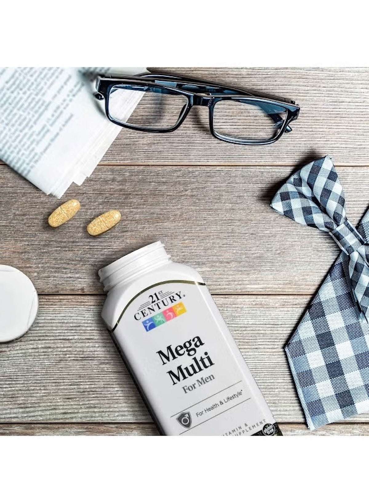 21st Century Mega Multi multivitamin supplement bottle with two capsules, glasses, and a bow tie