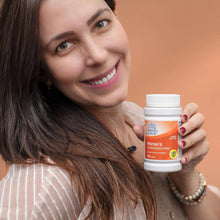 Woman holding a bottle of women’s multivitamin tablets, 100-count