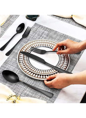 Huitich 24-piece dining flatware set in matte black with knife, fork, and spoon on decorative plates