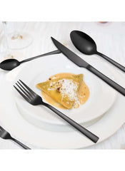Huitich 24-piece dining flatware set in matte black with fork knife and spoons on white plate