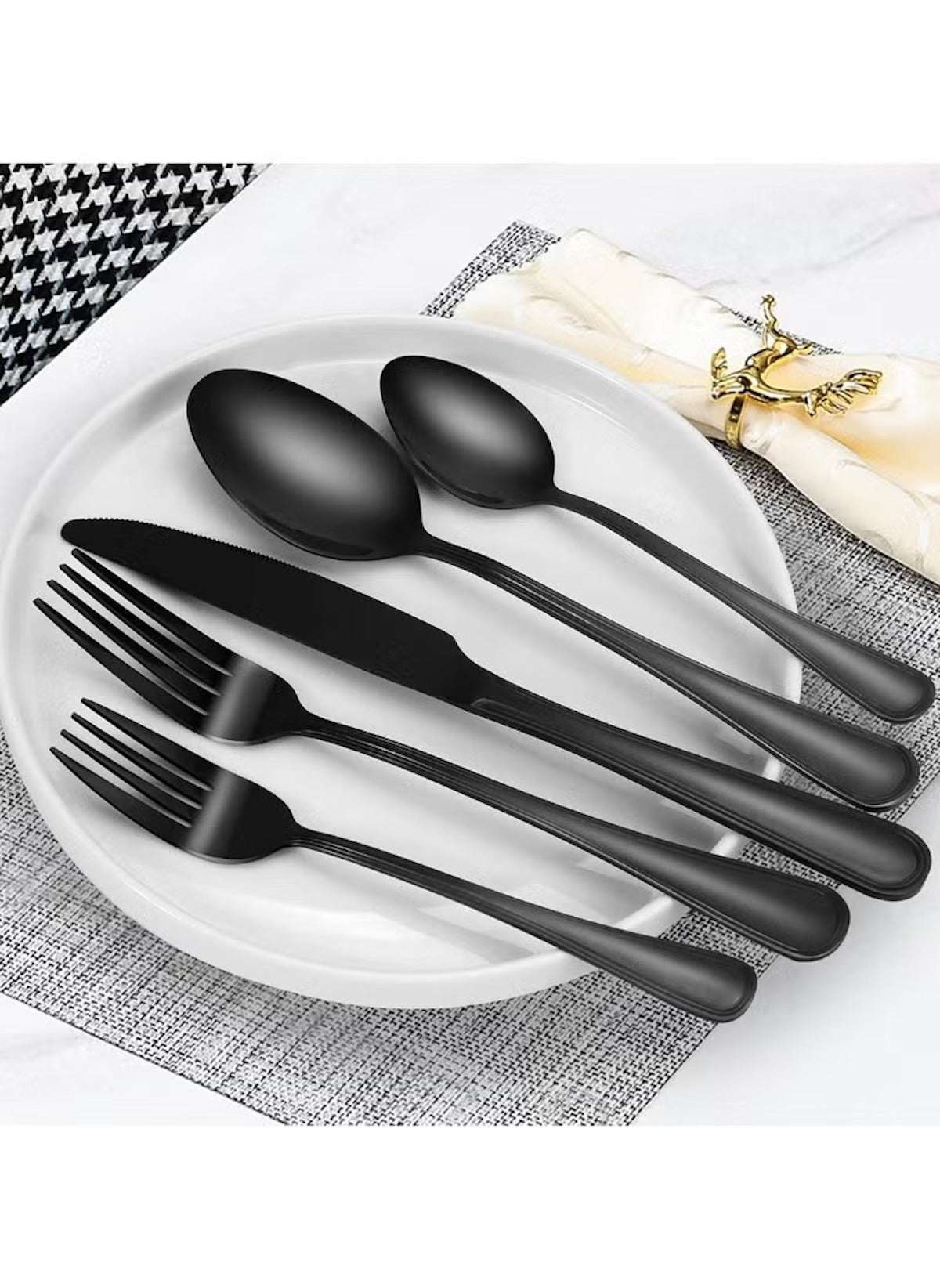 Huitich 24-piece dining flatware set in matte black finish with forks knives and spoons on white plate