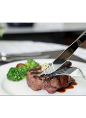 Huitich 24-piece dining flatware set cutting steak with fork and knife on white plate with broccoli