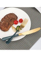Huitich 24-piece dinnerware set with stand featuring gold and black flatware with steak and vegetables on a white plate