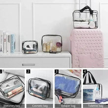 Clear PVC toiletry bag with black top handle, filled with assorted bottles and cosmetics