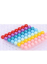 Water bead craft tray layout with stacked rainbow-colored bead hearts
