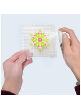 Water bead toy pegboard with multicolor flower design, hands holding beads