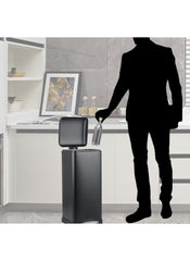 Huitich 30L pedal bin for kitchen in black with step-on lid open and person disposing bottle