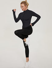 Black long-sleeve half-zip sports top with thumb-hole cuffs, paired with leggings