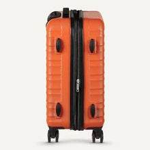 Orange hardside spinner suitcase close-up with black zipper and textured shell