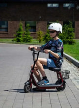 Kids electric scooter with seat, front basket, red frame in use