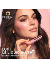 Liquid blush wand with berry mauve tint held near a model’s cheek
