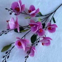 Purple artificial orchid flower stems with dark branches, green leaves, red centers