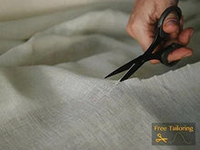 Unbleached cotton cheesecloth sheet being cut with scissors
