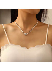 42cm silver crystal pendant necklace by Huitich worn on a woman's neck with a white scalloped top
