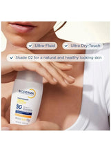 Tinted face sunscreen fluid being applied, Bioderma Photoderm bottle beside skin