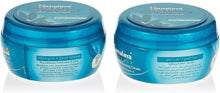 Blue body cream tubs with teal lids, sweet almond and wheatgrass label front