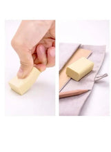 Yellow block eraser in hand, removing marks on sketch paper