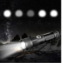 Black LED flashlight shining a bright beam in dark setting