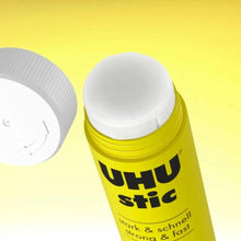 UHU stic glue stick with yellow body and white cap, close-up